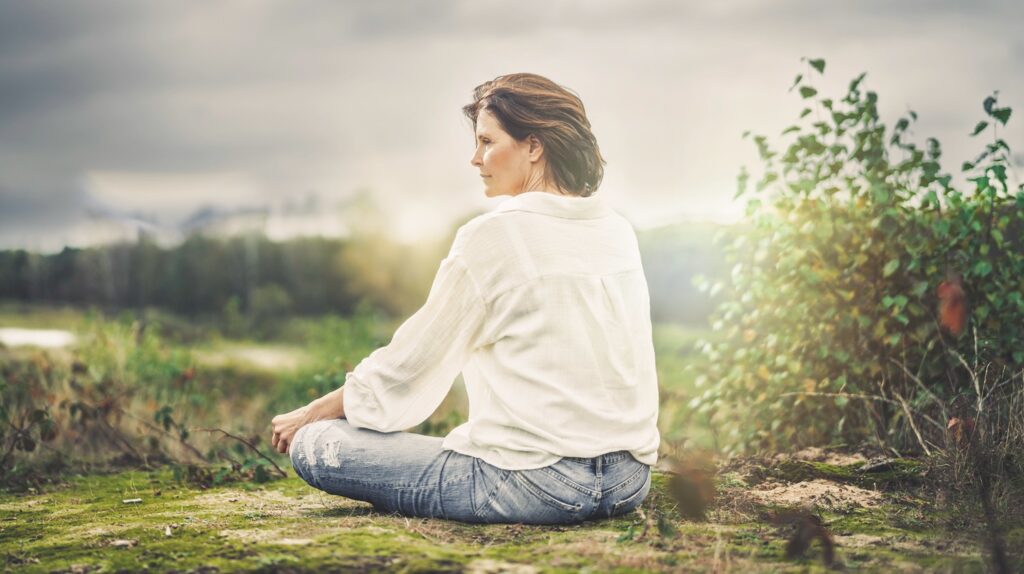woman sitting mindfully in nature